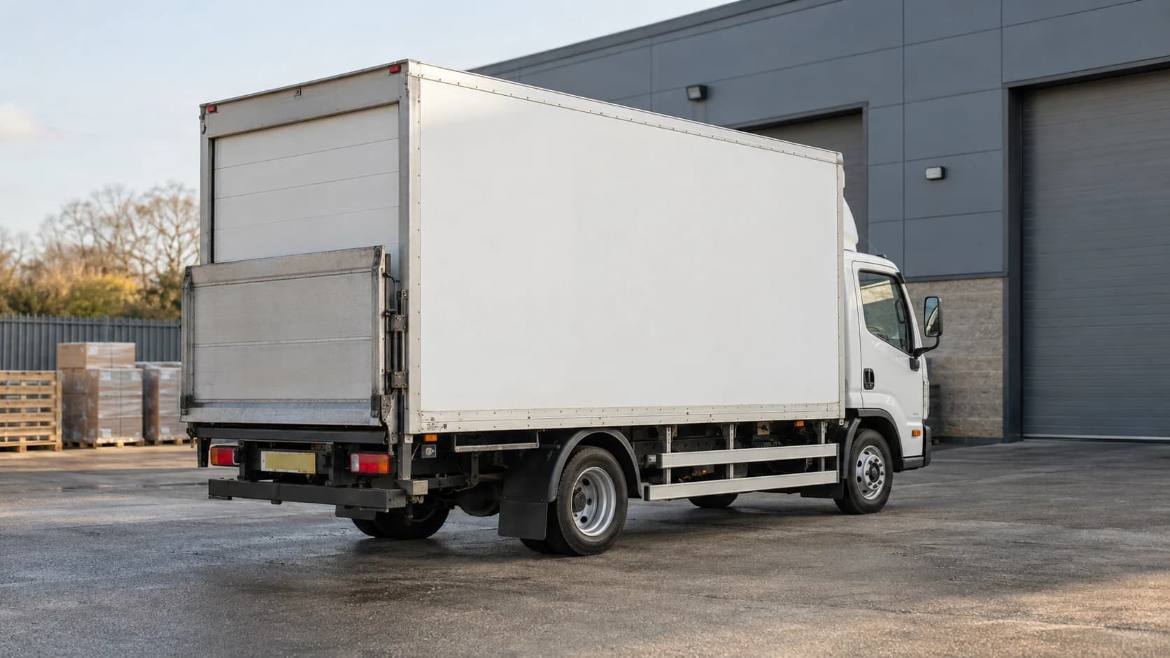 Compact white box lorry with its rear tail-lift folded for travel