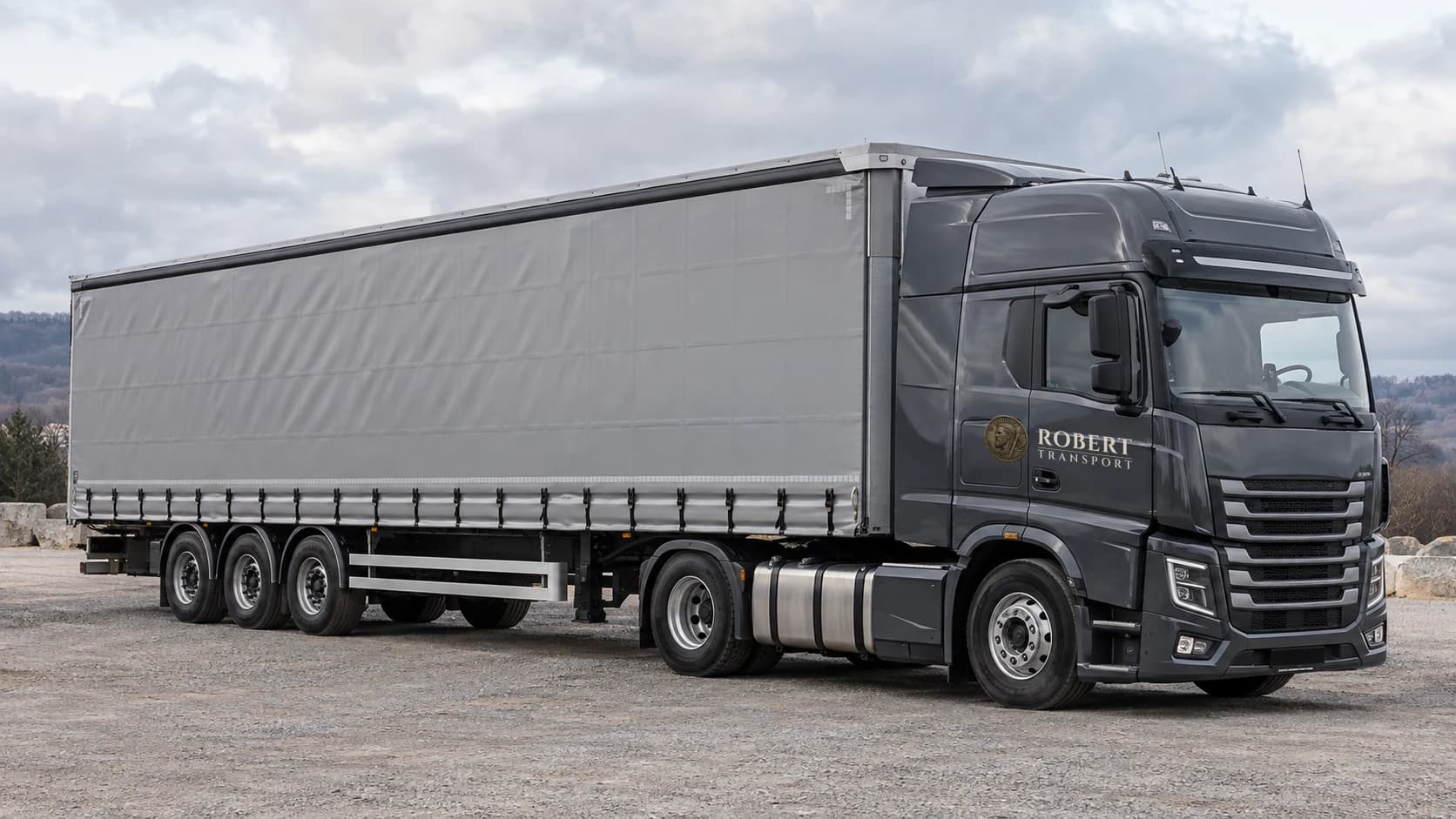 Charcoal tractor unit with a grey curtain-sided articulated trailer