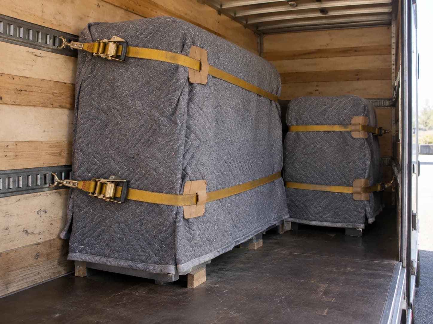 Blanket-protected equipment restrained inside a dedicated vehicle